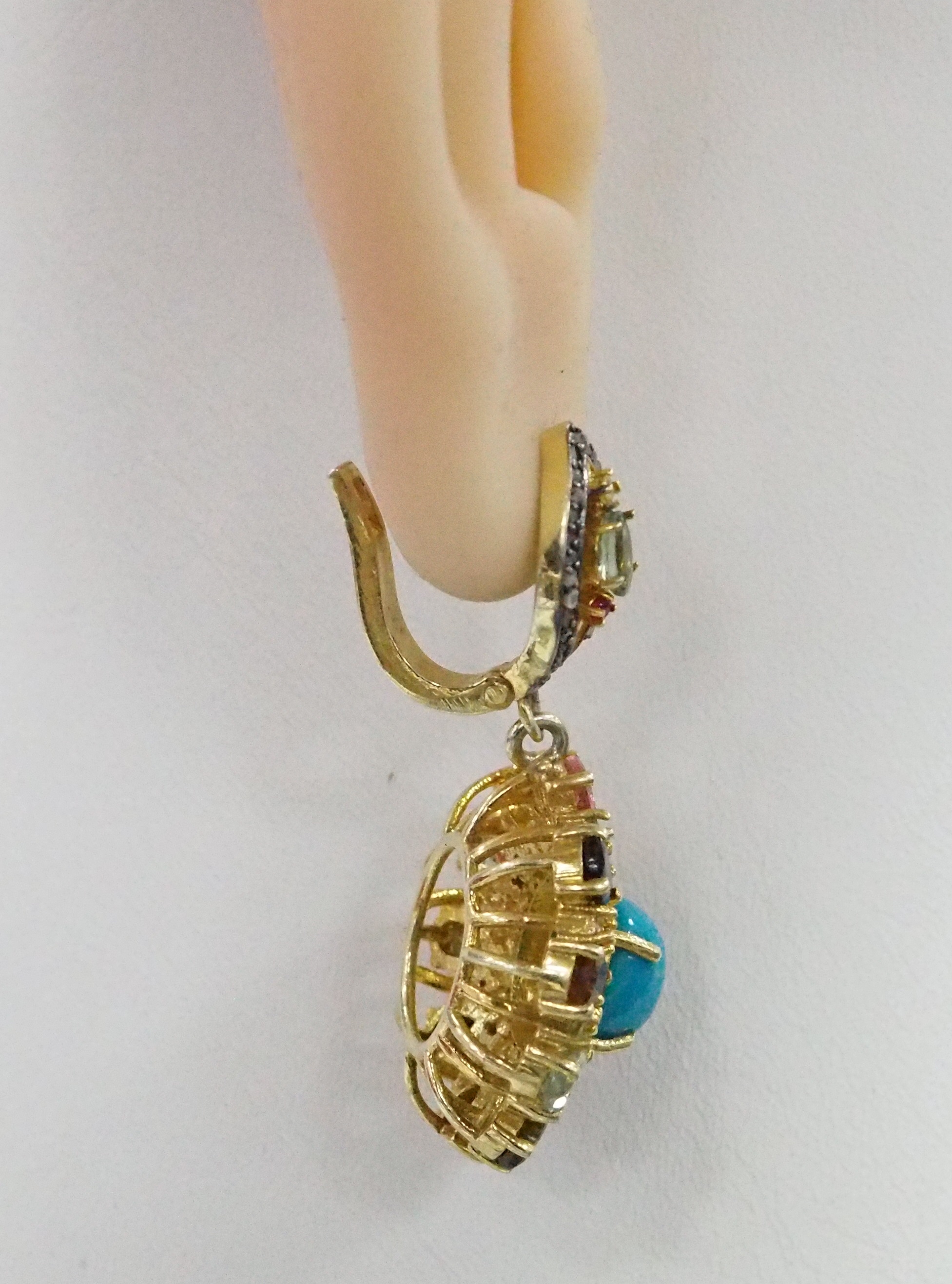 Серебряные серьги 925 пробы; вставки 2 Бирюза 5,04; 20 Турмалин цв.7,08; 2 Сапфир зел.0,6; 124 Бр.НВО 0,59 6/8; 2 Аметист 0,02; 14 Родолит 0,68; 2 Руб